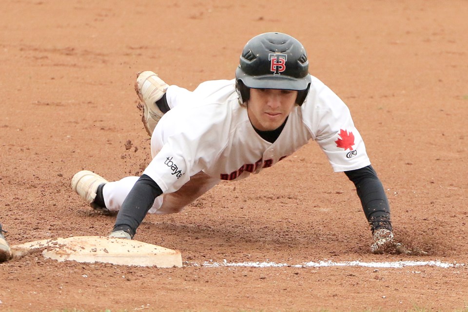 Lucas Terilli slides back safely into first for the Border Cats on Tuesday, July 2, 2024. (Leith Dunick, tbnewswatch.com)