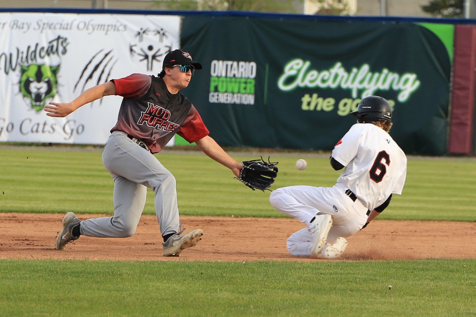 Thunder Bay's Lucas Terilli slides in safely as the ball gest past Minnesota second baseman Mathew Maulik on Friday, May 31, 2024. (Leith Dunick, tbnewswatch.com)