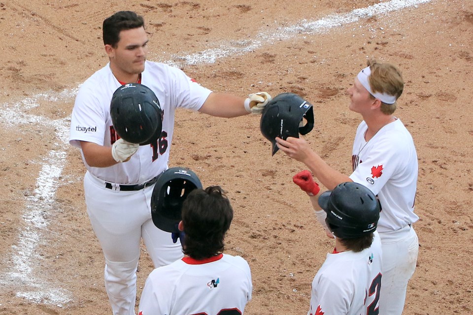 Jackson Cooke (left) is congratulated by his Thunder Bay Border Cats teammates on Wednesday, July 3, 2024 after hitting a three-run home run in the bottom of the fourth inning to help lead his team to a 7-4 win at Port Arthur Stadium. (Leith Dunick, tbnewswatch.com)