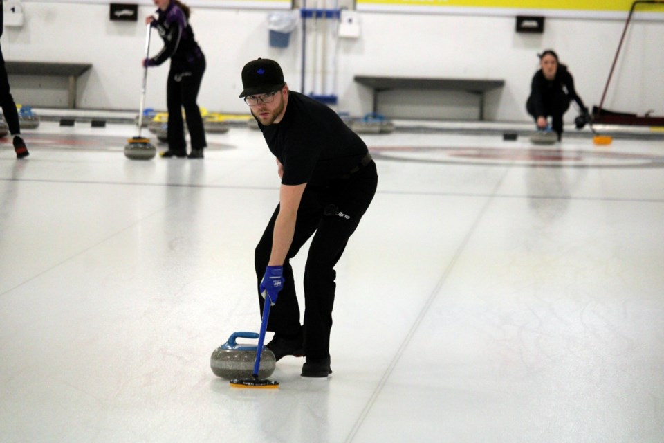 Connor Mangoff prepares to sweep a rock while teammate Kirsten Armstrong gets ready in the hack during a practice session at the Northern Ontario mixed doubles playdowns at the Kakabeka Falls Curling Club on Feb. 5, 2025.