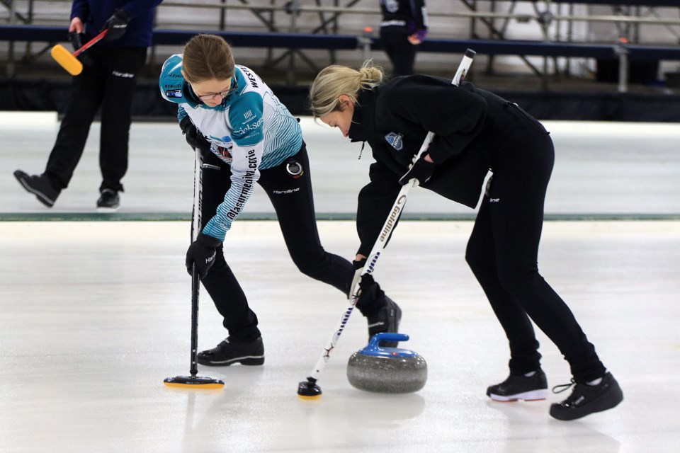 Team Despins' Nicole Westlund-Stewart (left) and Rebecca Carr sweep in Draw 11 action on Saturday, Jan. 25, 2025 at the Northern Ontario Women's Curling Championship at the Port Arthur Curling Centre. (Leith Dunick, tbnewswatch.com)