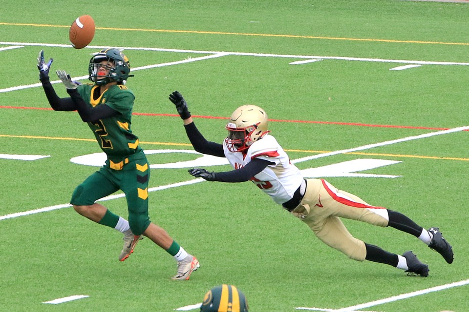 Saint Patrick's Jason Taw hauls in what turned out to be a 43-yard touchdown pass from Gordon Pawdomu, outracing Hammarskjold's Landen Legacy to the ball on Saturday, Nov. 2, 2024 in the junior football final. (Leith Dunick, tbnewswatch.com)