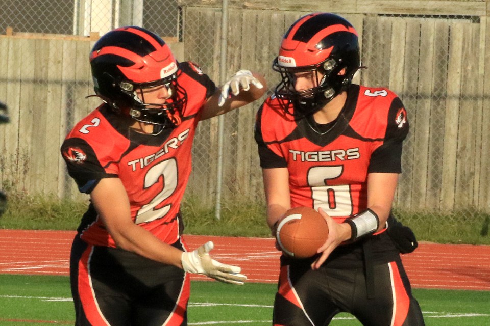 Westgate's Mitchell Papineau (right) hands the ball off to running back Hudson VanDyk on Friday, Oct. 18, 2024. VanDyk finished with 11 carries for 61 yards. (Leith Dunick, tbnewswatch.com)