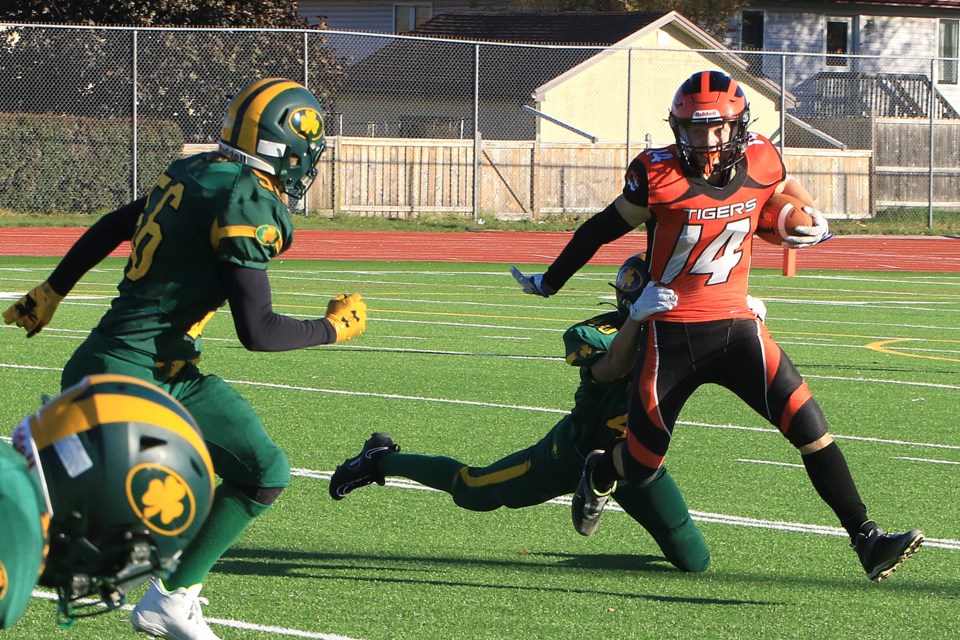 Westgate's Tyler Rose (14) tries to escape the grasp of St. Ignatius defender Easton Taylor on Friday, Oct. 11, 2204 at Fort William Stadium. 