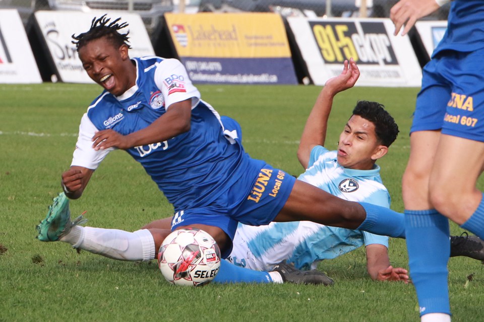 Thunder Bay's Abdoul Karim Pare is tackled by FC Manitoba's Kevin Lopez on Wednesday, July 5, 2023 at Chapples Field. (Leith Dunick, tbnewswatch.com)