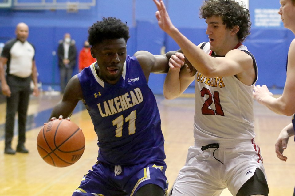 Lakehead's Nathan Bilamu (left) fends off Guelph's Matthew Oliver on Saturday, Feb. 12, 2022, on his way to the hoop at the CJ Sanders Fieldhouse. (Leith Dunick, tbnewswatch.com)