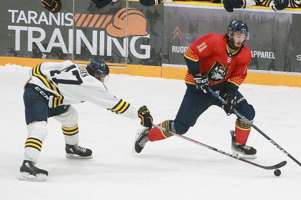 Lakehead's Nicholas DeGrazia tries to beat Windsor's Mason Kohn to the puck on Saturday, Feb. 3, 2024 at Fort William Gardens. (Leith Dunick, tbnewswatch.com)