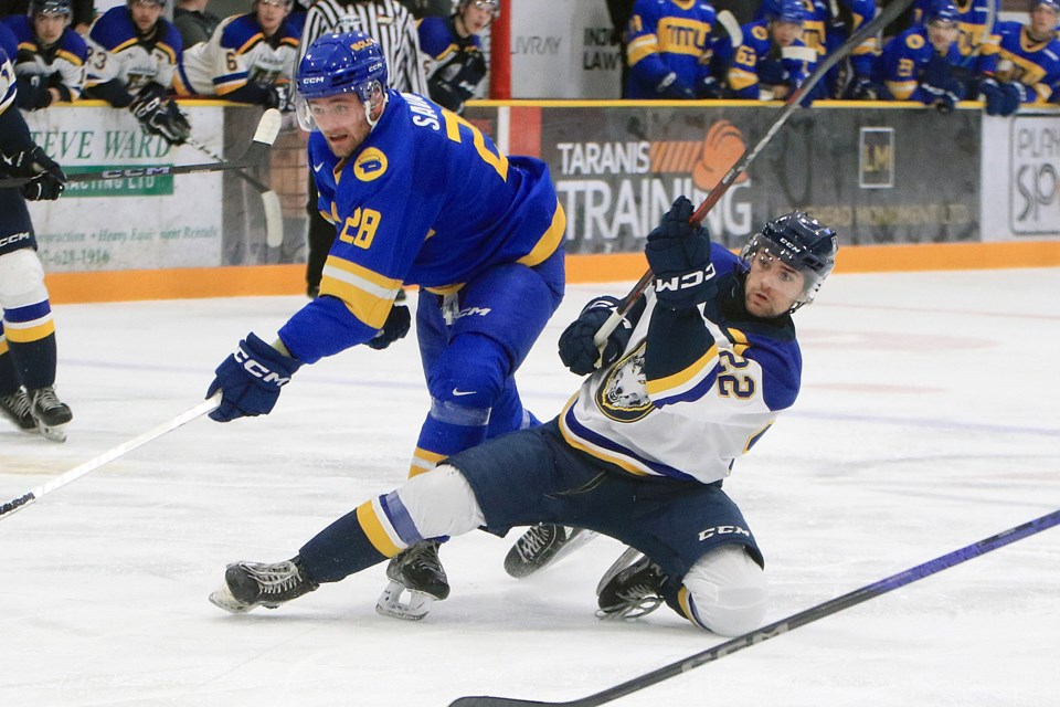 Lakehead's Alex Izyk (right) lets loose a shot in front of TMU Bold forward Tyler Savard on Friday, Oct. 25, 2024 at Fort William Gardens. (Leith Dunick, tbnewswatch.com)