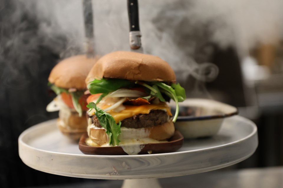 John Murray, the head chef and owner at Red Lion Smokehouse, prepares fresh Smoke Show burgers at the Red Lion Smokehouse on Dec. 5. Murray said making the burger sage smoked added a smoky hint to the flavour, but he also wanted to give guests an experience and a memorable moment with the burger.