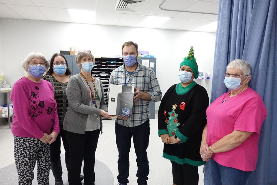 Thompson General Hospital OR department head Shane MacDonald, centre, receives a Bluetooth smart speaker from Thompson Health Auxiliary members, from left to right, June Bourguignon, Cathy Pellizarro, Wendy Lucas, Mervat Yehia and June MacTavish on Dec. 19.