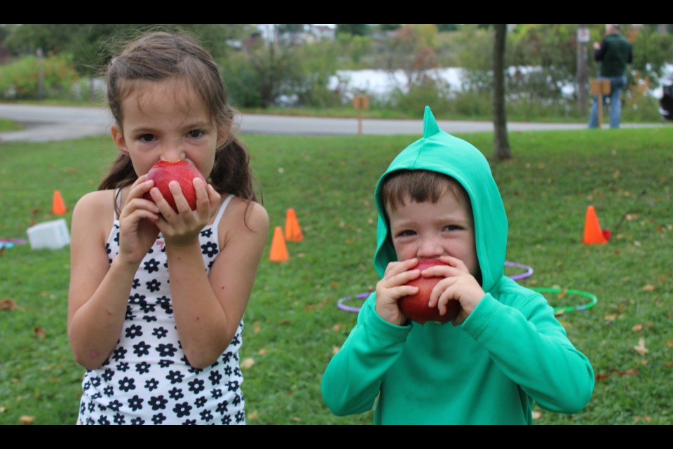 Millie, 5, and Artie Tilbrook, 3, of Thorold each take a big bite their apples at Historic Beaverdams Church on Saturday during Applefest.