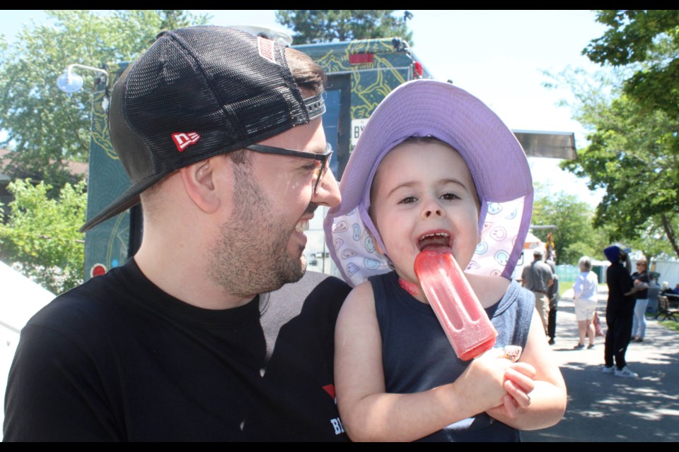 Four-year-old Lyric Golden enjoys a popsicle with her dad, Jason. The pair were at the Rock and Blues on the Battlefield event at the Battle of Beaverdams Park. The event is part of the City of Thorold's Canada Day weekend celebrations.