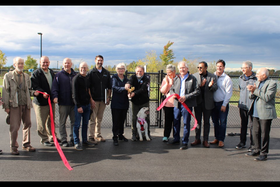 Jane and Ed Lipscombe, centre, cut the ribbon Tuesday to officially open what is now known as the Van Stralen-Griffiths Dog Park on Beaverdams Road. Joinging in the ceremony was the Lipscombe's dog, Lucy.