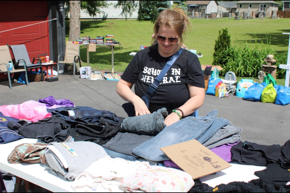 Jennifer Adkins folds jeans she had for sale at the Community Garage Sale in Port Robinson on Saturday.