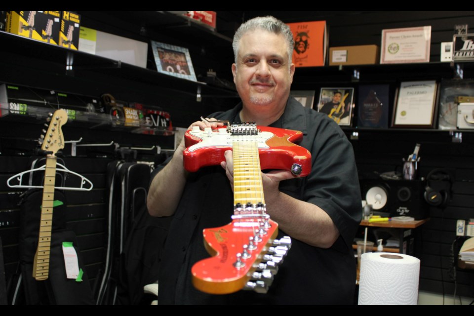 Mike Palermo makes sure the neck is straight on one of his custom made guitars -- the PG4 Mars Replica -- he sells through his own brand -- Palermo Guitars.
