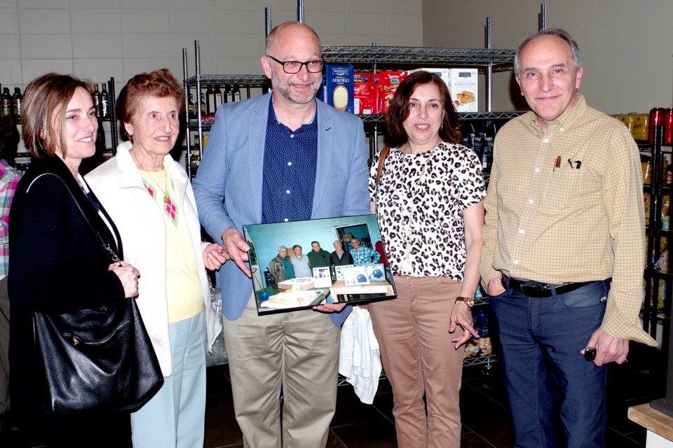 Long-time family friends (l-r) Carla Bufalino, Marisa Riganelli, Minister of Justice and Attorney General David Lametti, Cathy Cappelli, and Paul Riganelli pose with a photo of the bakery, which the Riganellis owned from 1957 to 1999. Bob Liddycoat / Thorold News