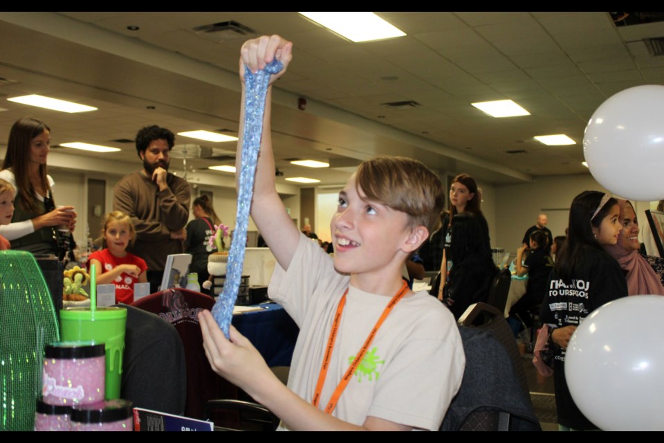 Landyn Eckhardt shows the elasticity of the slime he makes through his business DC Slimer. His was one of 37 businesses started by kids taking part in the Niagara Children's Business Fair on Saturday.