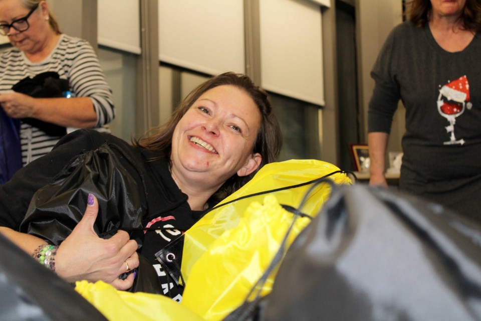 Barbie Hackett almost got lost among the pile of gift bags filled with men's gloves and personal care products that were assembled for Toolbox Project Niagara on Dec. 5. Hackett was one of more than 100 volunteers who were helping assemble the bags, which will eventually find their way to men experiencing homelessness across the region. Bags for women were assembled and distributed earlier.