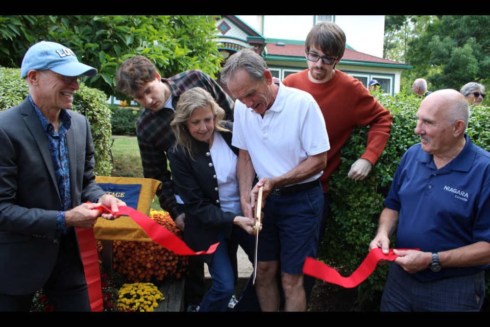 Janice and Mike McDowell cut a ribbon at a ceremoney to deisgnate their home -- the Williams-Daboll House -- as a property with cultural heritage interest under part 4 of the Ontario Heritage Act. The McDowells were joined by their children , Roy and Evan. Holding the ribbon in front were Thorold councillor Tim O'Hare, left, and Regional Coun. Tim Whalen.