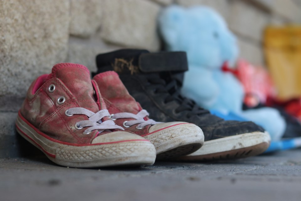 Community members brought shoes and toys to Hollinger Park to honour 215 children whose remains were found in an unmarked grave at the former residential school in Kamloops, B.C.