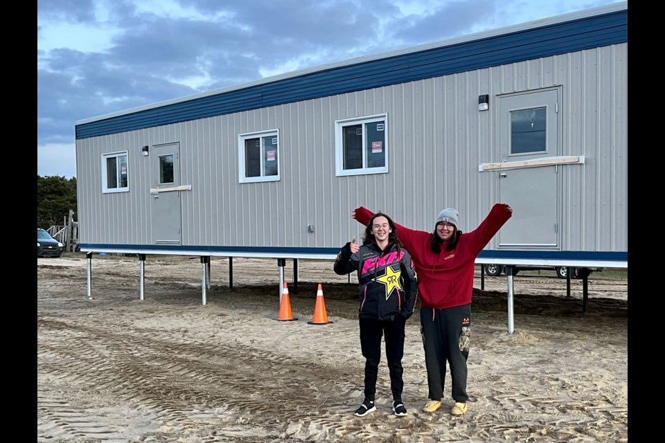 Students Kylea Naveau and Tamiika Naveau watch the new classroom going up.