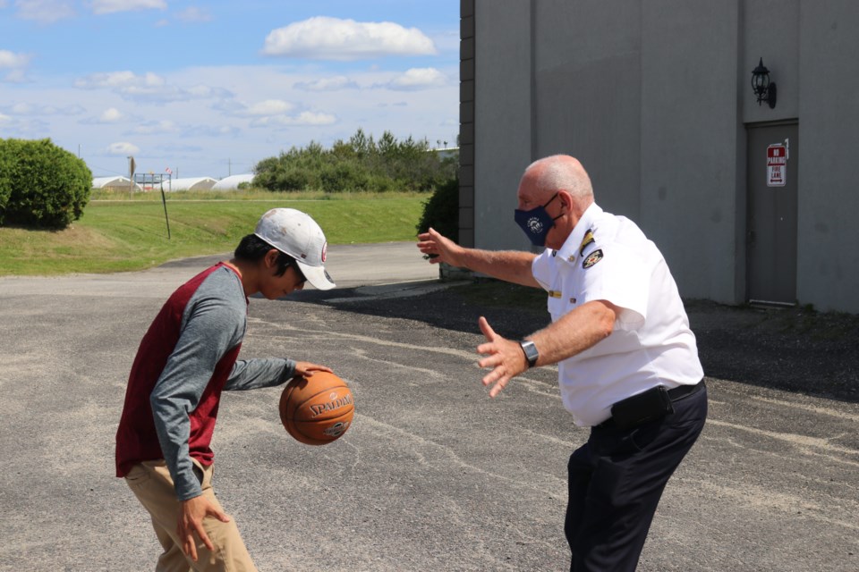 Tom Laughren plays ball with an evacuee from Pikangikum First Nation in 2021. 