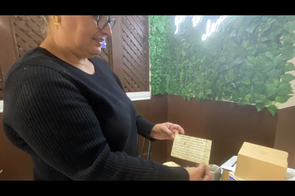 Kanwaljit Bains with the documents she and the staff at the Punjabi Restaurant found in the walls during renovations.