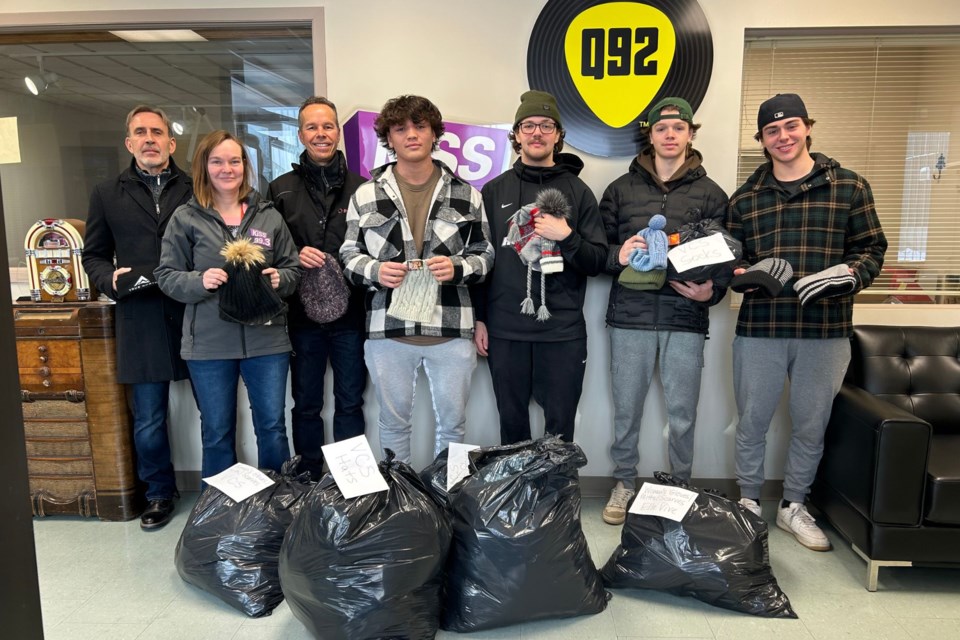 Timmins Rock players and Q92/KiSS 99.3 staff with all of the toque toss donations for ElleVive and Timmins and District Victim Services.