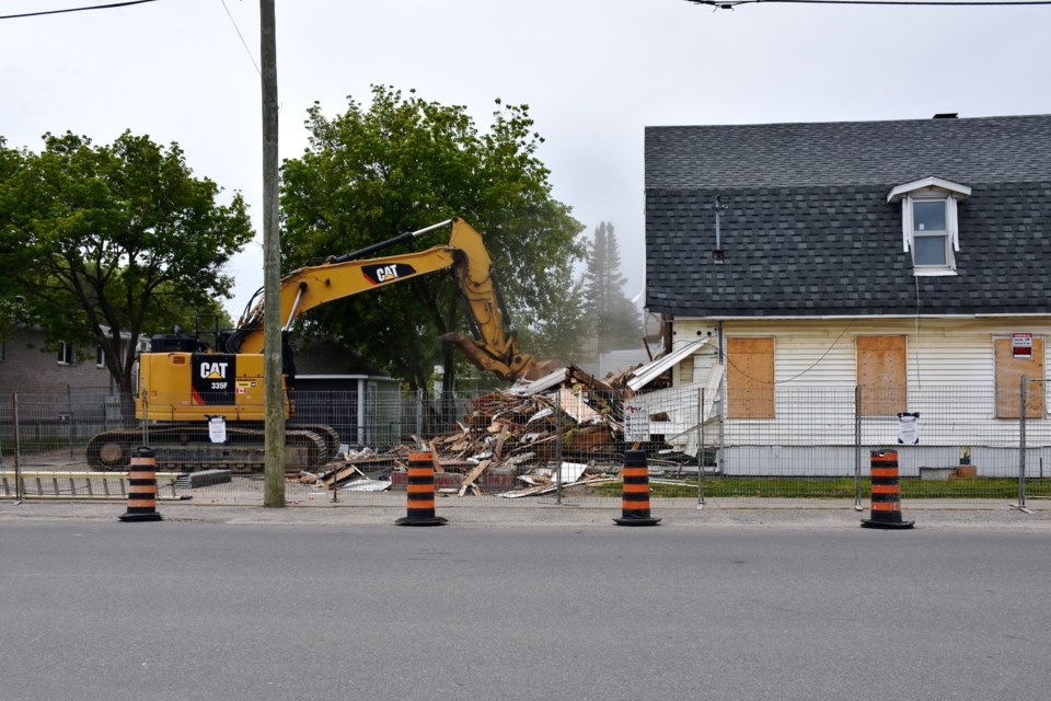 Crews demolish a vacant building on Spruce Street South across from Living Space on July 22.