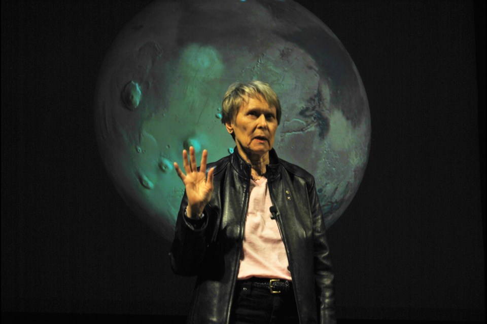 Dr. Roberta Bondar standing in front of a photo of the moon challenged Timmins and area students to care about the earth. Frank Giorno for TimminsToday