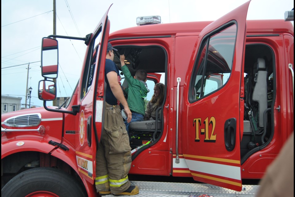 Hey mom look at me. A youngster gets a thrill sitting behind the wheels of a big red fire truck. Photo:  Frank Giorno, timminstoday.com