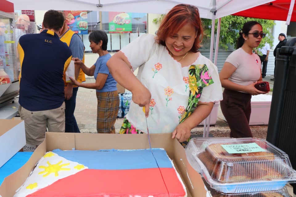 Estela Chow cuts the cake at the third annual Filipino Fiesta.