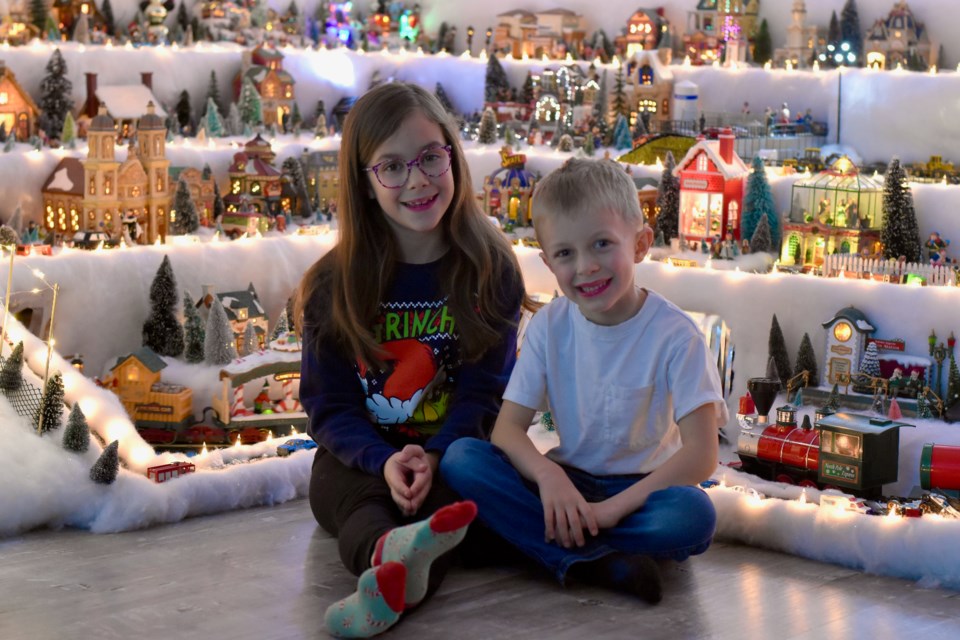 Camille and Simon Coutu in front of their grandparents' huge Christmas village.