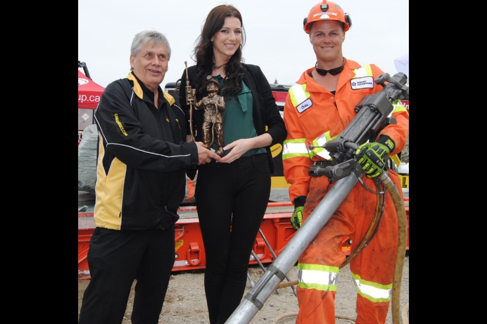 Natalie Carriere (centre) proudly displays her first prize trophy for winning the celebrity jack leg competition. (Left) Jay Cornelsen event organizer  and Chris Bourrie, jackleg Drill  supervisor and coach