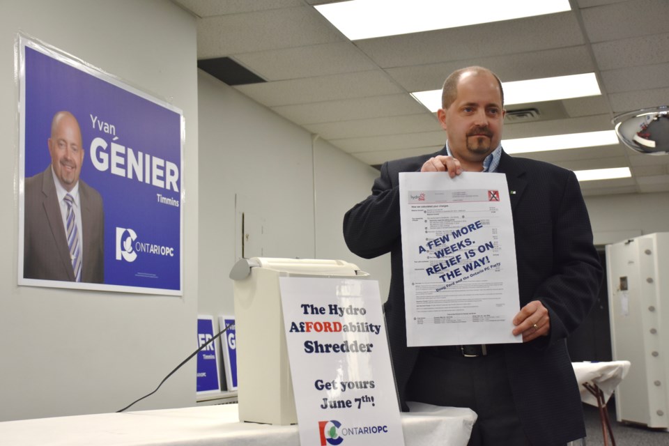 Timmins PC candidate Yvan Genier shreds a hydro bill at the opening of this campaign office downtown Timmins. Maija Hoggett/TimminsToday