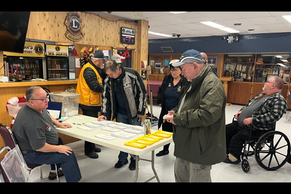 John McCauley, chairman of the Stan Fowler Christmas Fund, gives instructions to volunteers from the Schumacher Lions Club about the deliver of $150 food vouchers to families with children.