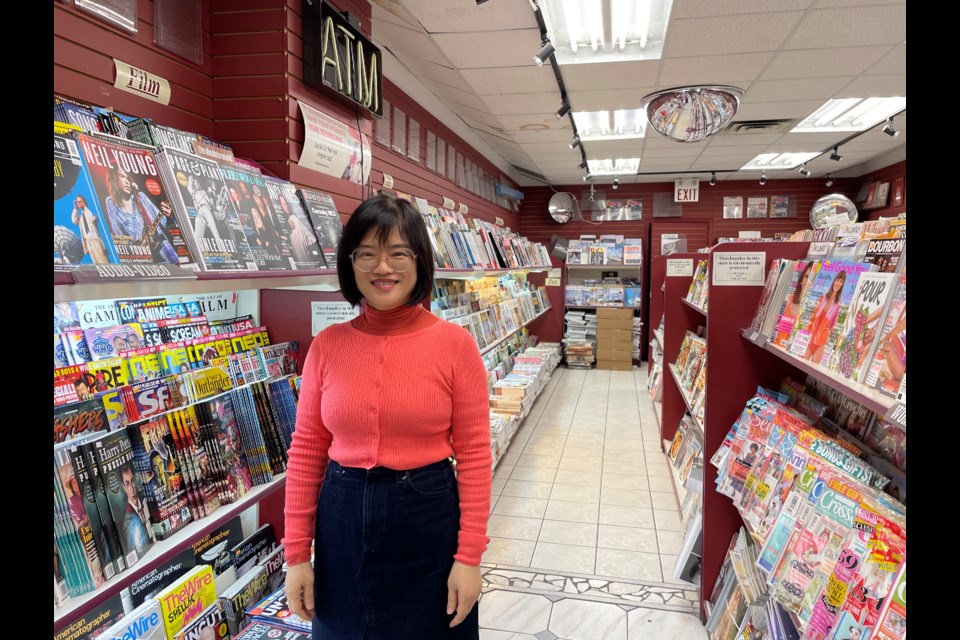 Co-owner Edith Yang stands among the rows of shelves in Presse Internationale.