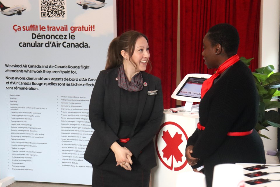 Air Canada Rouge flight attendant Shanyn Elliott (left) spent the weekend sharing concerns over the airline's alleged lack of compensation for unpaid work at a downtown pop-up exhibit.