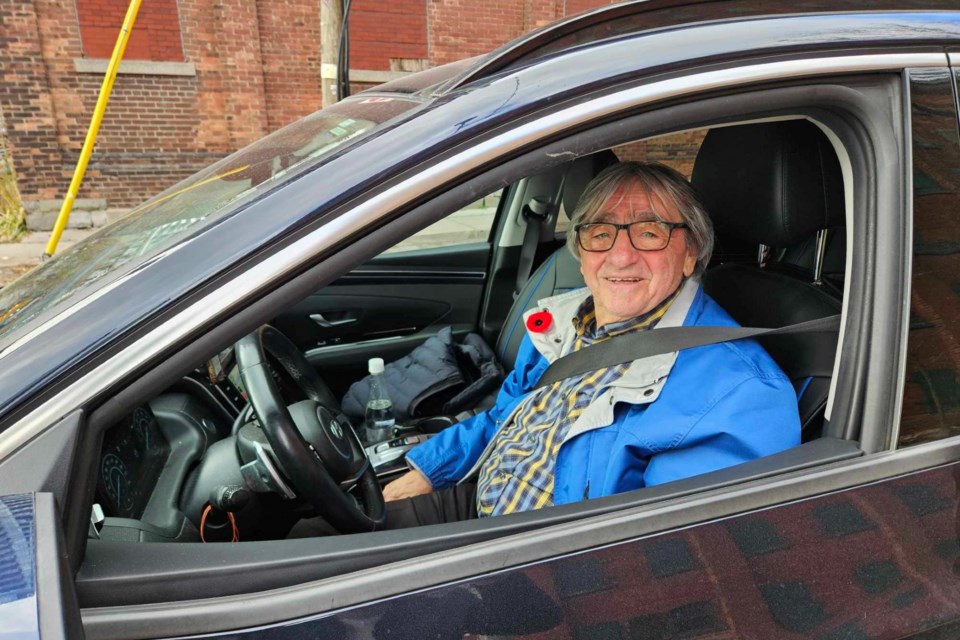 A smiley Rocco Cornacchia drops off one of his Uber passengers at the Distillery Winter Village.