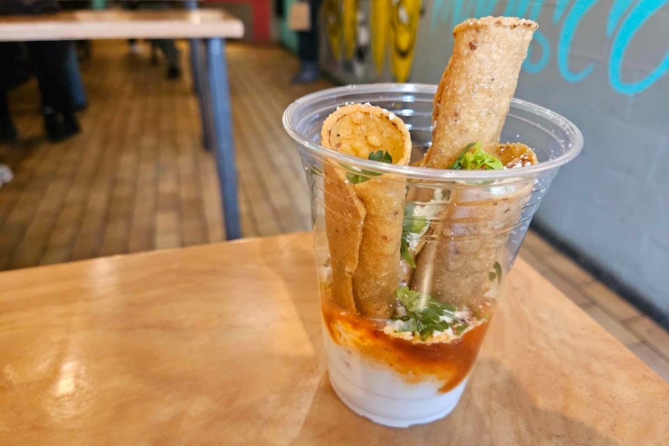 Flautas are served in a cup and dipped into salsas, cheese and cilantro at Seven Lives.