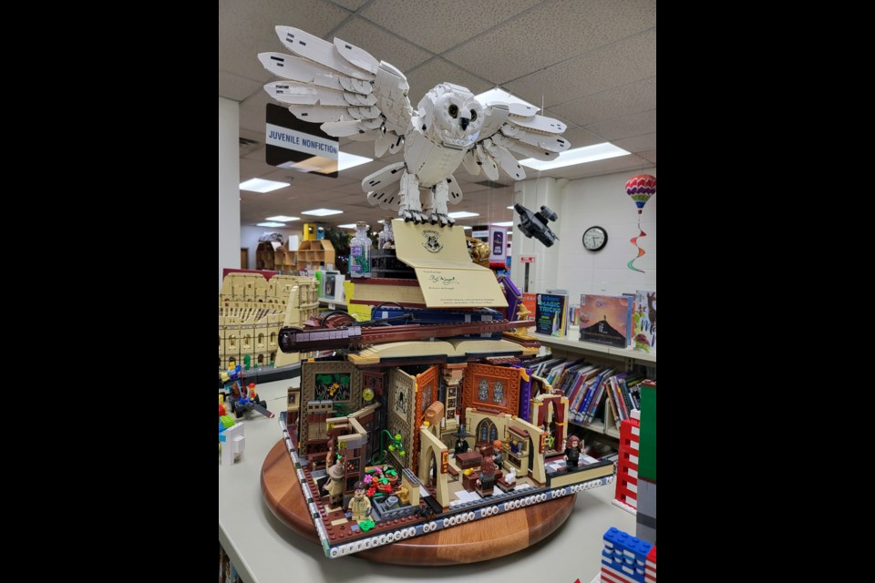 Kyle Hughes (Mr Lego) built this Harry Potter themed showpiece out of three anniversary LEGO kits. It is on display at the library.
There are movie quotes along the base, different classrooms from the movies and the impressive owl on top of books.