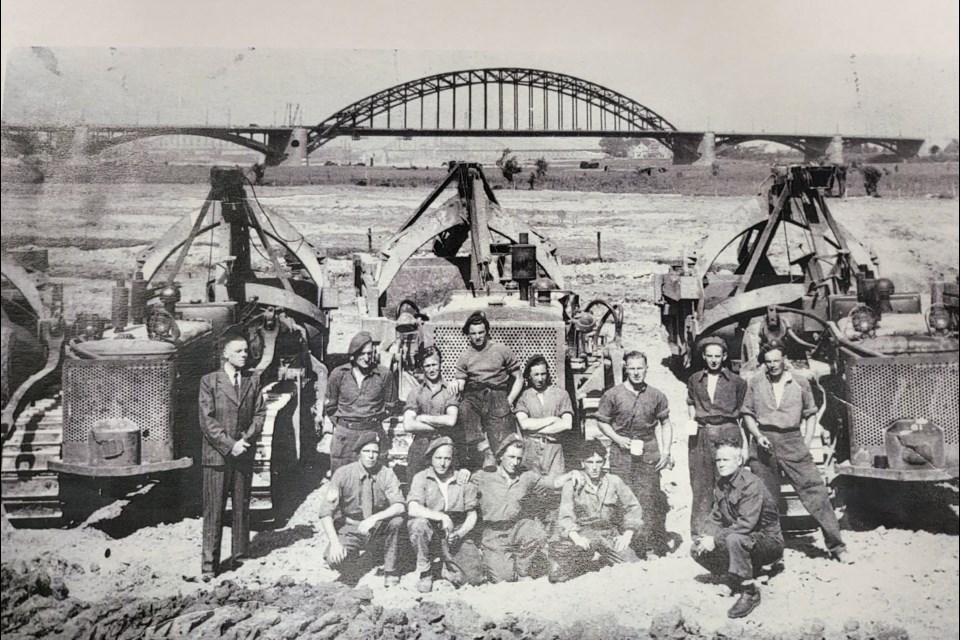 Andrew Carnegie, shown kneeling bottom right, was part of this crew that re-built the Holland bridge seen in the background in one day after it had been bombed. The mayor of the Holland own is shown standing on the far left. Picture supplied by Belinda Highbaugh, grand-daughter of Carnegie. 