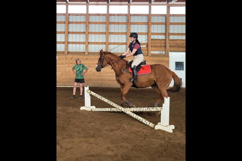 Noreen Pinder, horse jumping coach, offers feedback to Jenny Murray at camp practice session on July 11