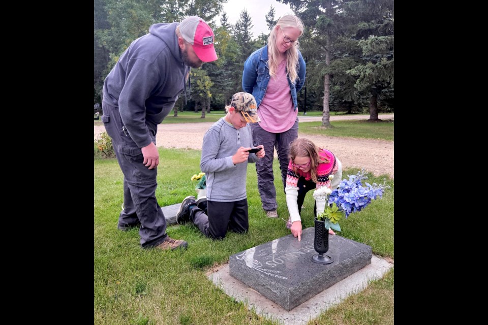 The Reiten family of Westlock, was one of several participants in a genealogical project, hosted by the Westlock Library, Sept. 11, at the Westlock Cemetery. The project involved using the BillionGraves app to take and upload photos of graves and headstones to help preserve information for people researching family history or graves of loved ones. Looking at a grave and taking a photo are L-R: Kristian and Jill Reiten and their childen Katrina and Robert. 
Kristine Jean/WN  
