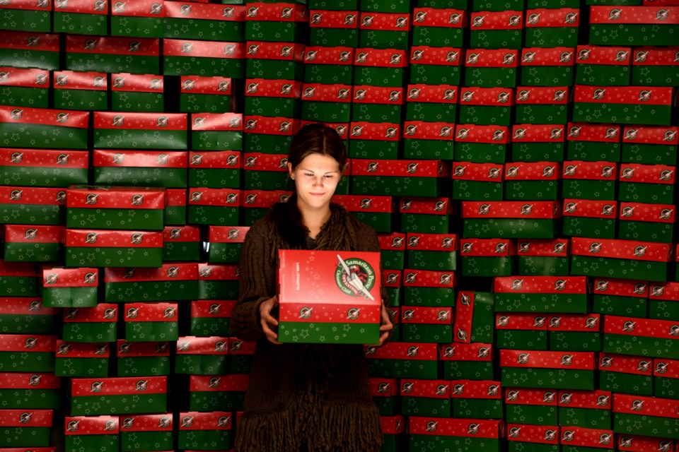 Morgan Bysterveld stands in front of a small mountain of Operation Christmas Child shoeboxes during a packing party at the Barrhead United Church on Nov. 18.