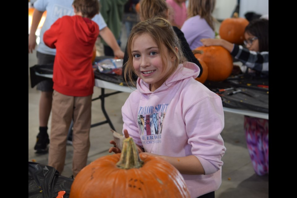 Alyta Tomm-Amell looks up from carving her jack-o-lantern.