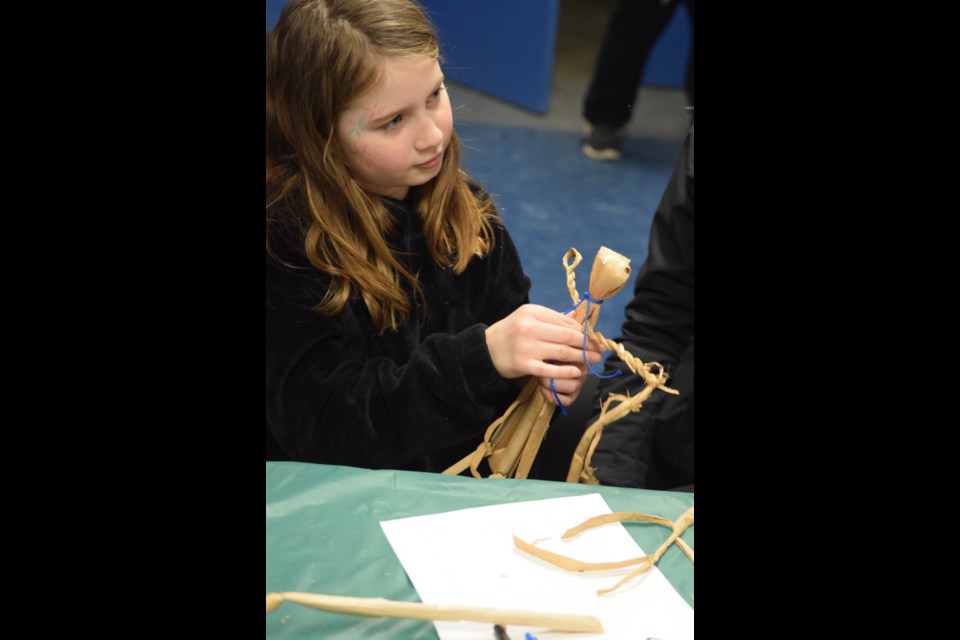 Amelia Wierenga, 9, making a corn husk doll