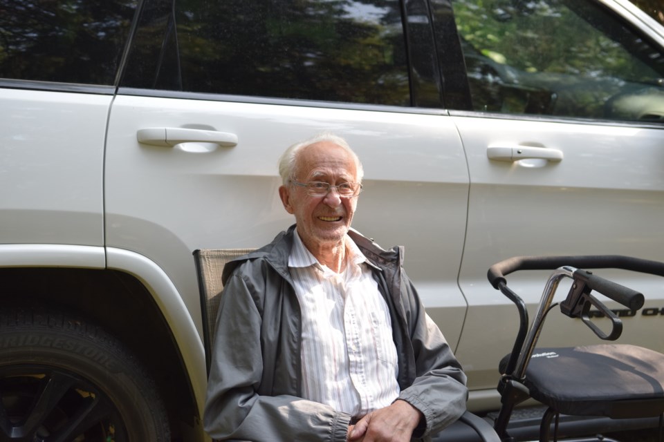 Art Gibbs, now 92, and one of the people who started the restoration of the Bethel Baptist Cemetery watches as the new grave markers are installed.