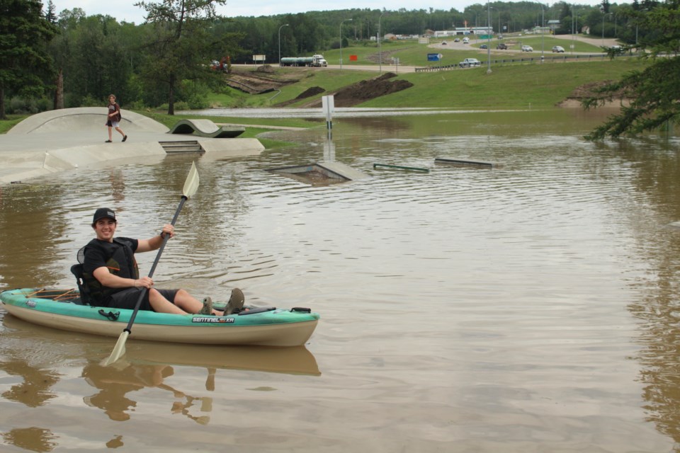 Caden Heasley took the “once in a lifetime” opportunity to break out his kayak and paddle through the Athabasca Skatepark June 23 around 1 p.m.