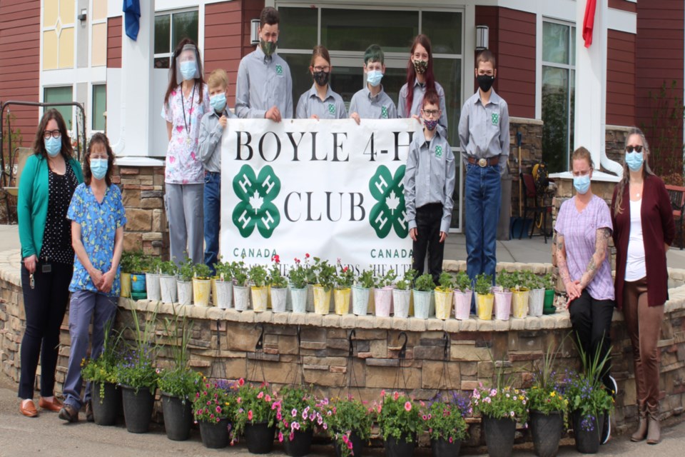 The Boyle 4-H Club donated around $1,000 worth of plants to the residents of the Wildrose Villa and $1,000 cheque to the Boyle Healthcare Centre Auxiliary May 17. L-R: Assistant manager Laura Hynes, staff Yvonne Winger, staff Wendy Chromiak, club treasurer Mark Splane, vice president Justin Chamzuk, district representative Holly Chamzuk, Remington Turner, secretary Ryleigh Turner, Rexson Turner, president Dean Splane, staff Jolynn Schulte, Wildrose Villa manager Hollie Tataryn. Missing: Kate Attfield, Jaci Attfield